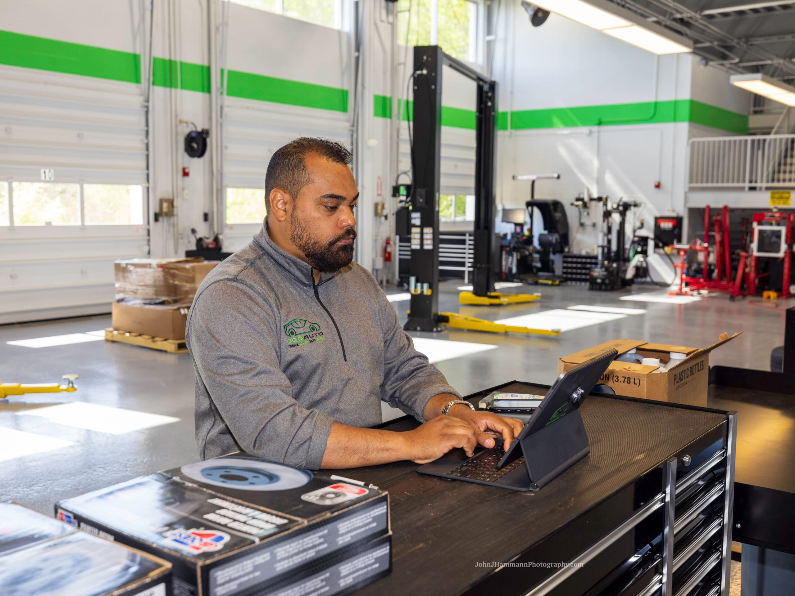 Eco Auto service advisor reviewing vehicle details with customer on laptop